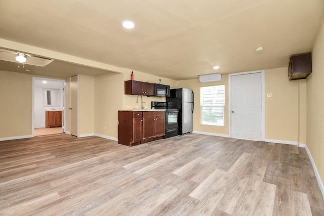 kitchen with baseboards, a wall mounted air conditioner, light wood-type flooring, light countertops, and black appliances