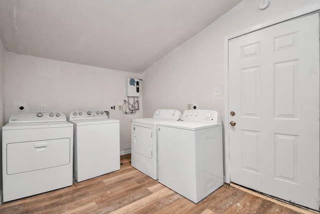 clothes washing area featuring laundry area, washing machine and dryer, and light wood finished floors