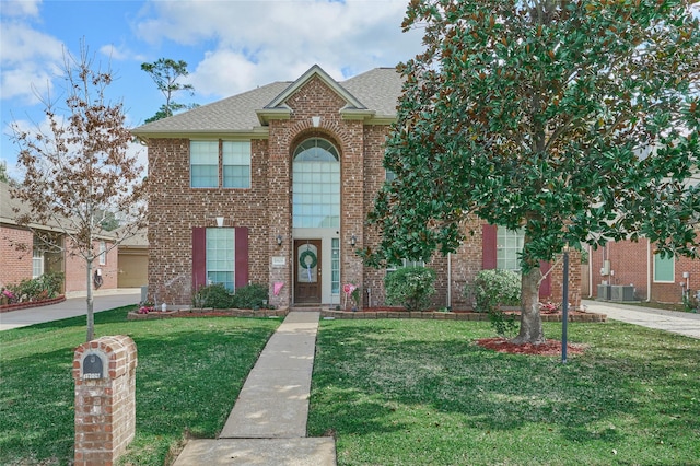 19106 S Rim Trl, Spring, TX 77388 - traditional home featuring a shingled roof, cooling unit, a front lawn, and brick siding