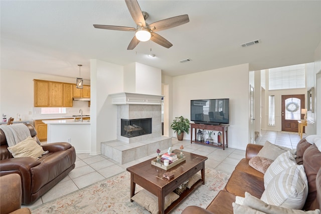 19106 S Rim Trl, Spring, TX 77388 - living area with visible vents, a ceiling fan, light tile patterned floors, and a tiled fireplace