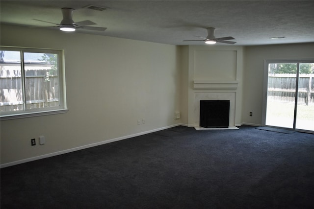 20018 Big Timber Dr, Humble, TX 77346 - unfurnished living room with a ceiling fan, a fireplace with flush hearth, dark carpet, and baseboards