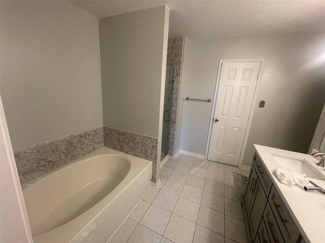 20018 Big Timber Dr, Humble, TX 77346 - full bath with tile patterned floors, vanity, a garden tub, a stall shower, and a textured ceiling