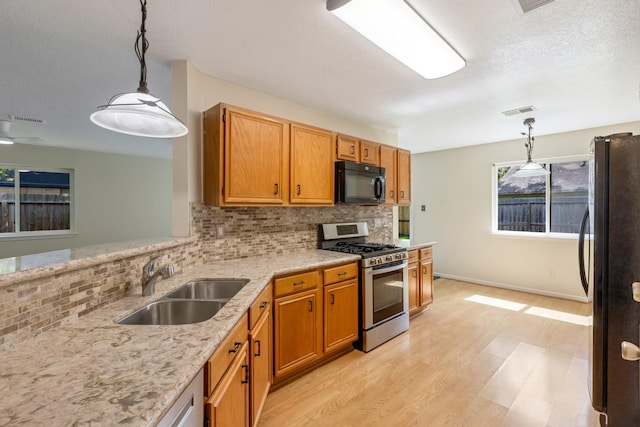 20018 Big Timber Dr, Humble, TX 77346 - kitchen with black appliances, a sink, tasteful backsplash, and light wood-style floors