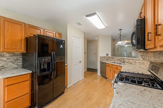 20018 Big Timber Dr, Humble, TX 77346 - kitchen featuring black appliances, a sink, tasteful backsplash, and light wood-style floors