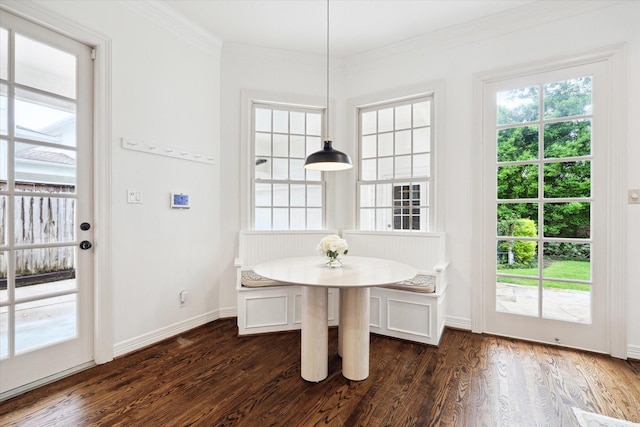 unfurnished dining area featuring dark wood finished floors, breakfast area, ornamental molding, and baseboards
