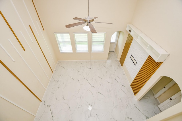 6326 Prince Place Dr, Rosenberg, TX 77471 - unfurnished living room featuring marble finish flooring, ceiling fan, healthy amount of natural light, and baseboards