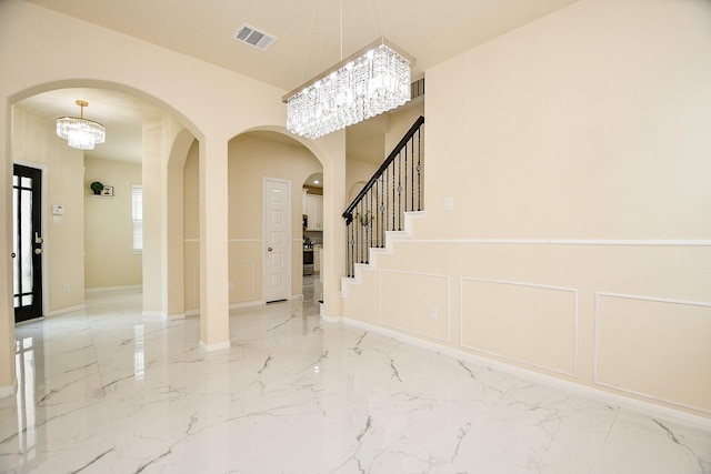 6326 Prince Place Dr, Rosenberg, TX 77471 - foyer featuring marble tiled flooring, arched walkways, a chandelier, and stairway
