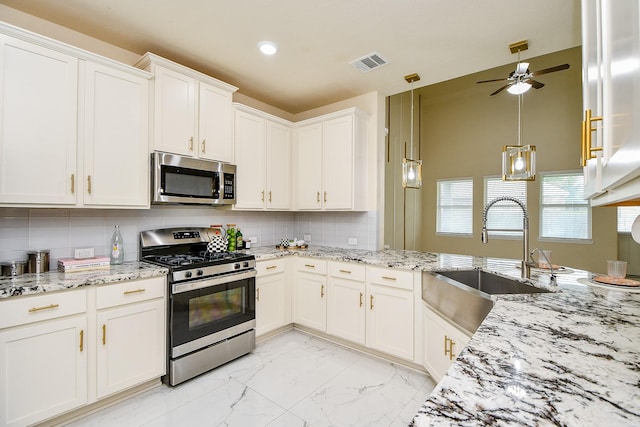 6326 Prince Place Dr, Rosenberg, TX 77471 - kitchen featuring appliances with stainless steel finishes, a sink, white cabinetry, light marble finish flooring, and backsplash