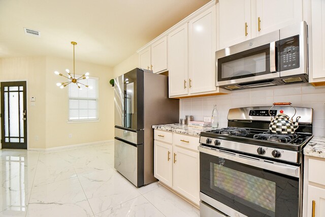 6326 Prince Place Dr, Rosenberg, TX 77471 - kitchen featuring appliances with stainless steel finishes, backsplash, light marble finish flooring, a chandelier, and white cabinetry