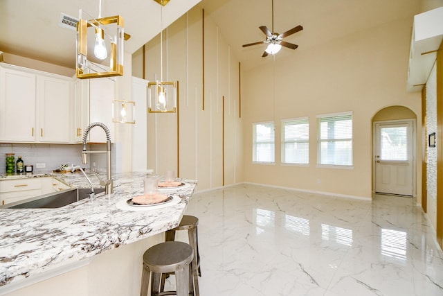 6326 Prince Place Dr, Rosenberg, TX 77471 - kitchen featuring a sink, high vaulted ceiling, ceiling fan, healthy amount of natural light, and white cabinetry