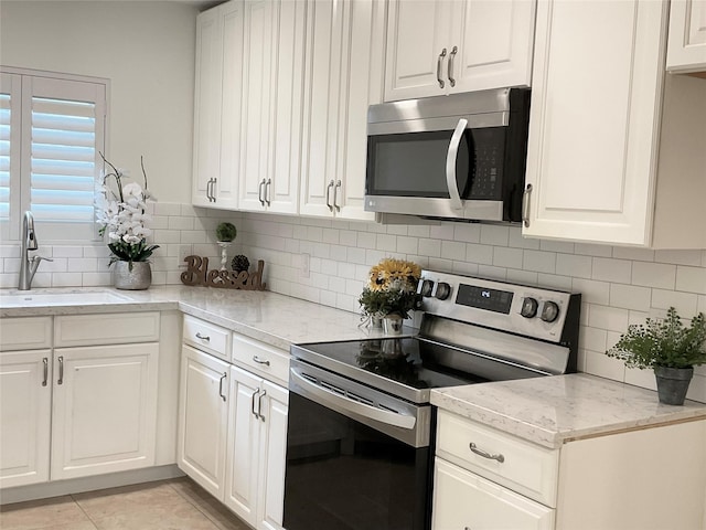kitchen with a sink, appliances with stainless steel finishes, and white cabinets