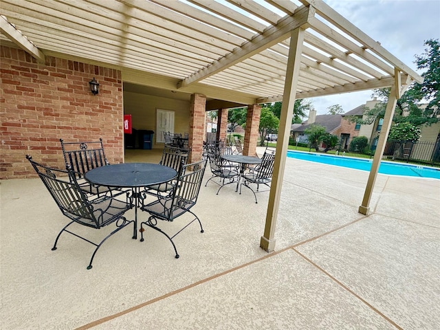 view of patio featuring a fenced in pool, fence, a pergola, and outdoor dining space