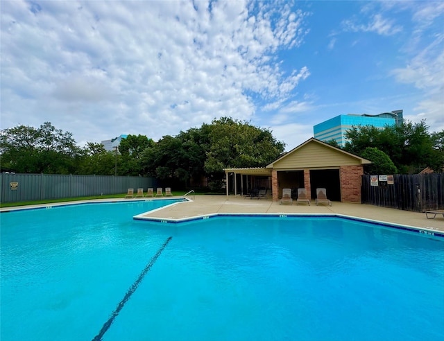 community pool with fence and a patio area
