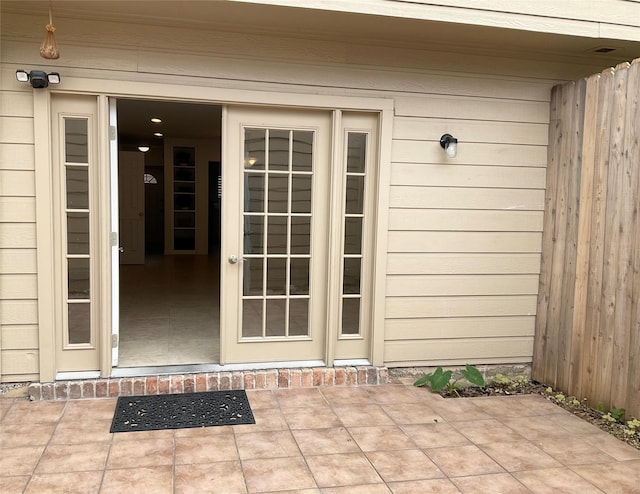 property entrance featuring fence and a patio area