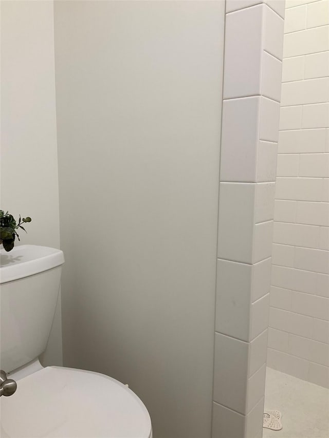 bathroom with toilet and a tile shower