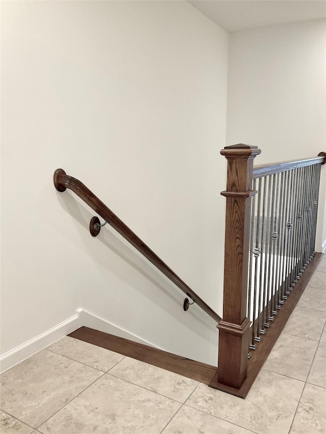staircase with baseboards and tile patterned floors