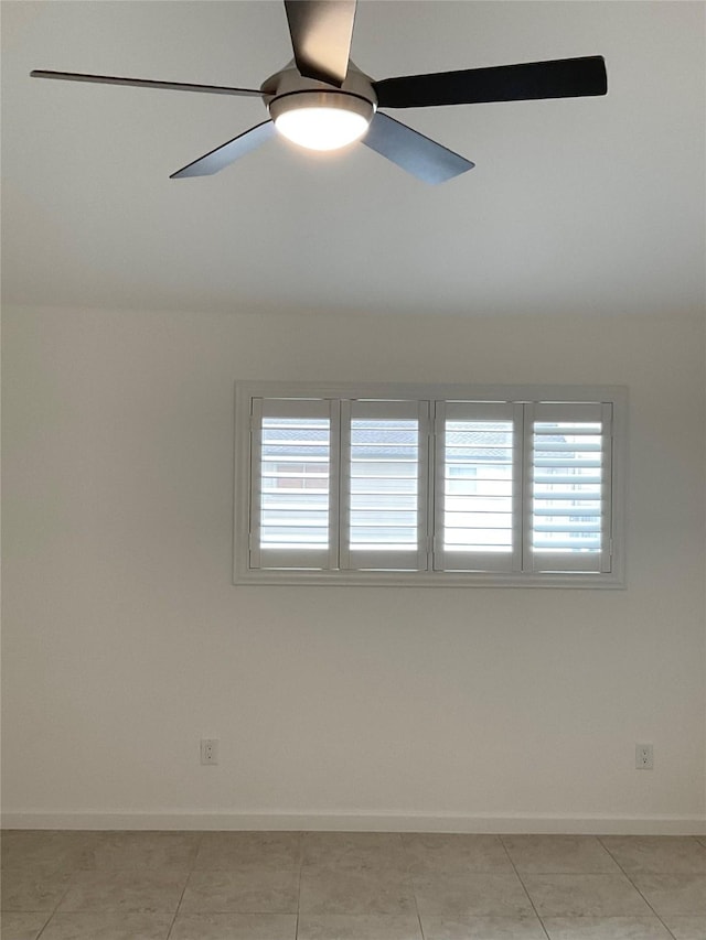 spare room featuring a healthy amount of sunlight, baseboards, and ceiling fan