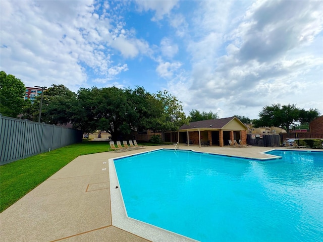 community pool featuring a yard, fence, and a patio area