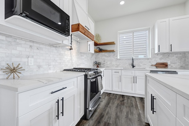 2104 Bringhurst St, Houston, TX 77026 - kitchen with stainless steel gas range, a sink, black microwave, decorative backsplash, and recessed lighting
