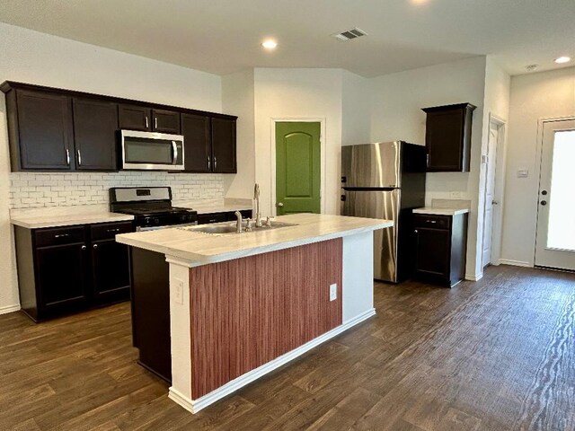 14670 Canyon Pines Ln, New Caney, TX 77357 - kitchen featuring stainless steel appliances, a sink, dark wood finished floors, light countertops, and backsplash