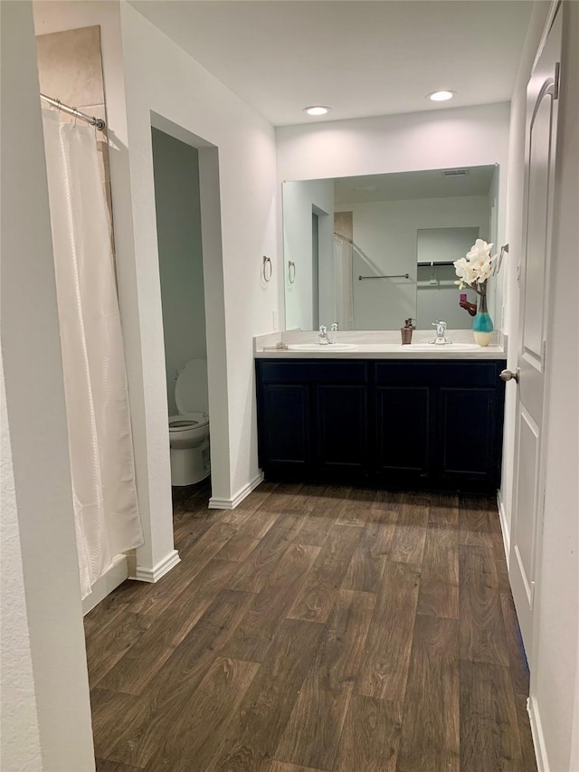 14670 Canyon Pines Ln, New Caney, TX 77357 - bathroom with wood finished floors, toilet, double vanity, baseboards, and recessed lighting