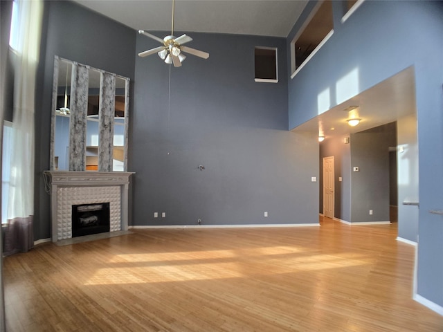3905 Austin Lake Ct, Pearland, TX 77581 - unfurnished living room featuring wood finished floors, a brick fireplace, ceiling fan, and a high ceiling