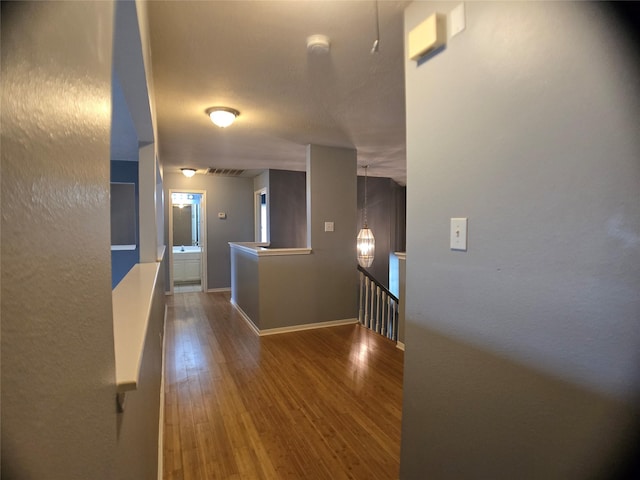 3905 Austin Lake Ct, Pearland, TX 77581 - hall featuring baseboards, an upstairs landing, and wood finished floors