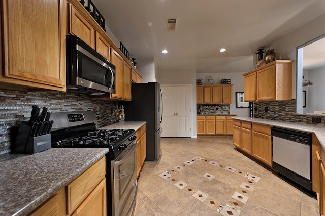 3905 Austin Lake Ct, Pearland, TX 77581 - kitchen with decorative backsplash, visible vents, appliances with stainless steel finishes, recessed lighting, and light tile patterned flooring