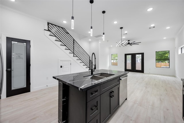 3020 Retta St, Houston, TX 77026 - kitchen with visible vents, dark cabinets, a sink, light wood finished floors, and dishwasher
