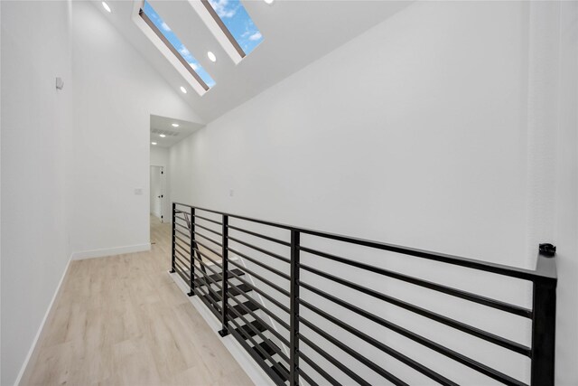 3020 Retta St, Houston, TX 77026 - corridor featuring a skylight, light wood-type flooring, baseboards, high vaulted ceiling, and recessed lighting