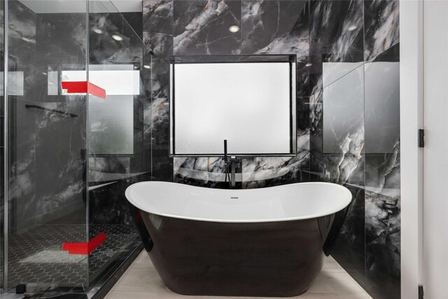 3020 Retta St, Houston, TX 77026 - bathroom featuring a freestanding tub, a tile shower, and tile walls