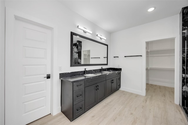 3020 Retta St, Houston, TX 77026 - full bath with double vanity, wood finished floors, a sink, baseboards, and a spacious closet