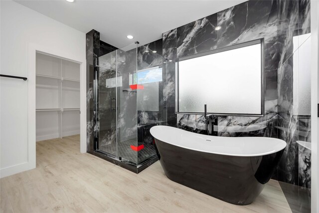 3020 Retta St, Houston, TX 77026 - bathroom with a freestanding bath, recessed lighting, wood finished floors, a spacious closet, and a stall shower