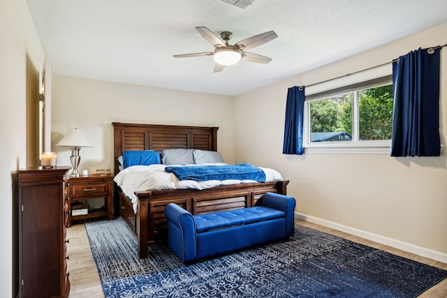 bedroom with light wood-style flooring, baseboards, and ceiling fan