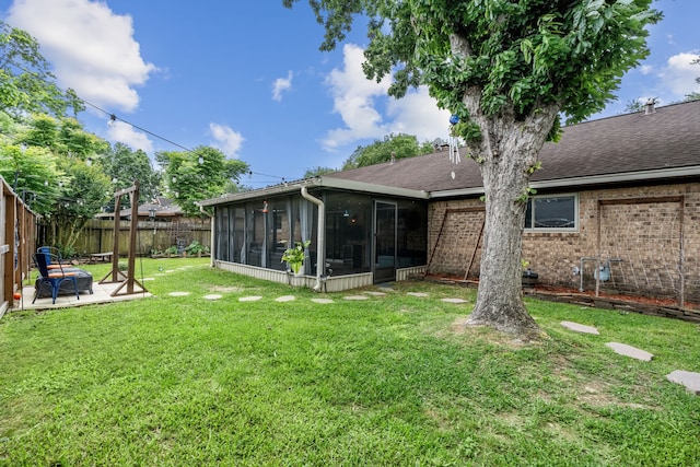 rear view of property featuring a sunroom, roof with shingles, and brick siding
