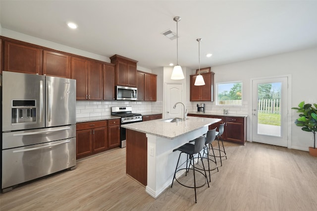 1202 Casal Springs Ct, Crosby, TX 77532 - kitchen featuring visible vents, light wood-type flooring, a sink, appliances with stainless steel finishes, and backsplash