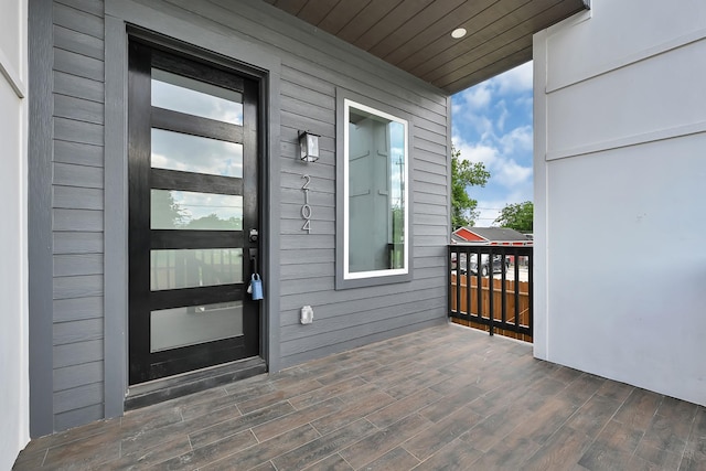 view of exterior entry with a balcony