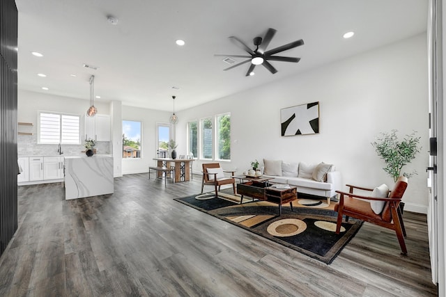 living room with plenty of natural light, recessed lighting, dark wood-style flooring, ceiling fan, and baseboards