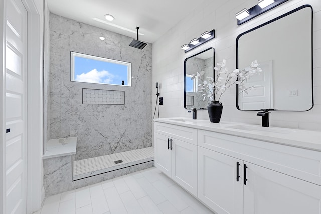 bathroom featuring a marble finish shower, double vanity, and tile patterned flooring
