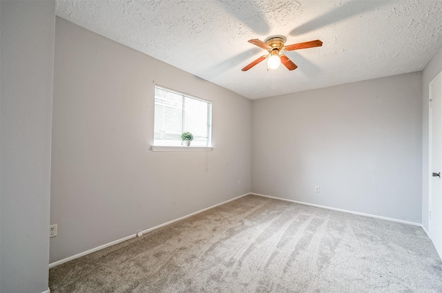 spare room featuring carpet floors, a textured ceiling, ceiling fan, and baseboards