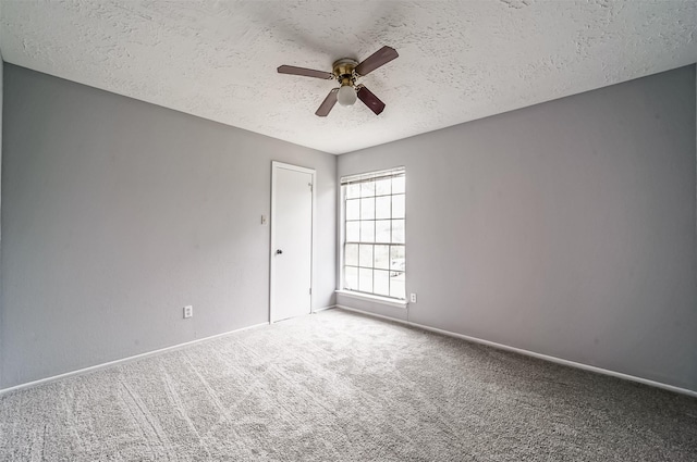 carpeted empty room with a ceiling fan, a textured ceiling, and baseboards