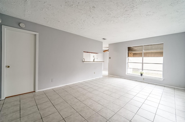 unfurnished room featuring light tile patterned floors, a textured ceiling, and visible vents