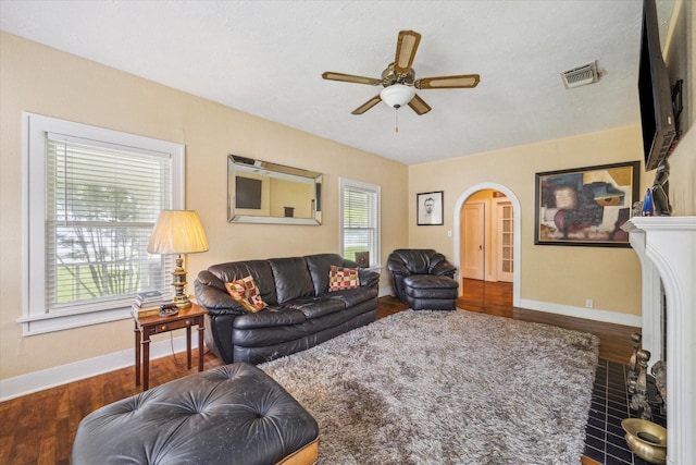 504 S Jackson St, Alvin, TX 77511 - living room featuring wood finished floors, a ceiling fan, visible vents, baseboards, and arched walkways
