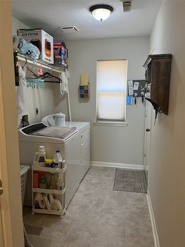 laundry area with washer and clothes dryer, visible vents, and baseboards