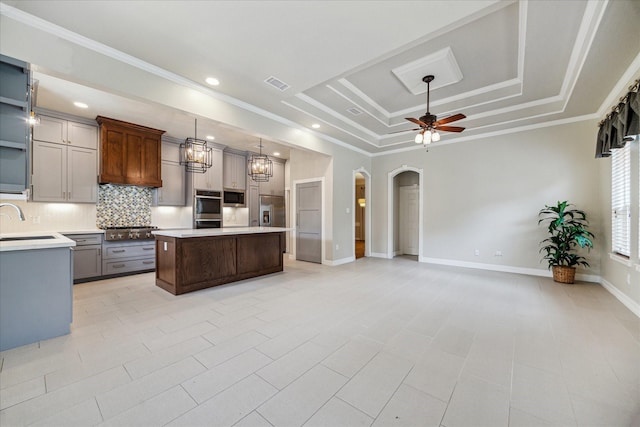 kitchen featuring ceiling fan, built in appliances, arched walkways, a tray ceiling, and visible vents