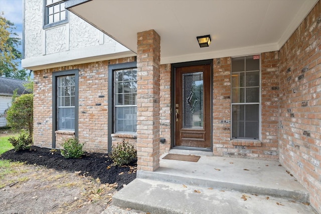 view of exterior entry with brick siding