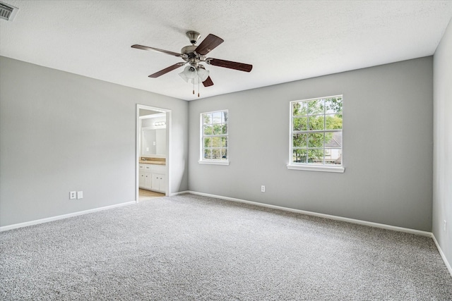 spare room featuring light colored carpet, baseboards, ceiling fan, and visible vents