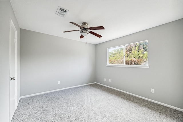 carpeted spare room featuring ceiling fan, visible vents, and baseboards