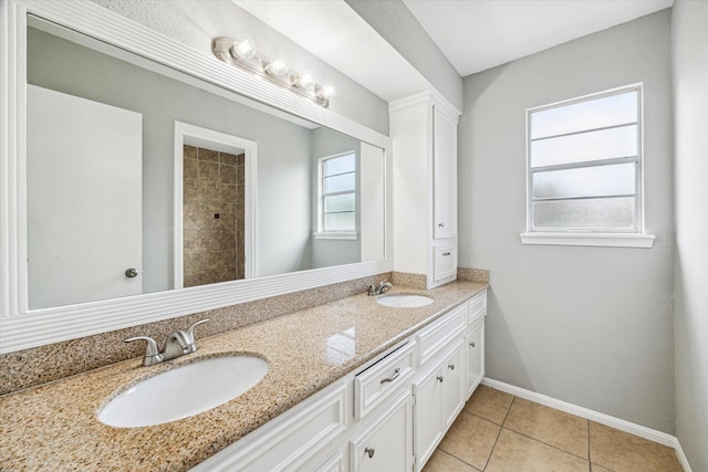 full bathroom featuring a sink, tile patterned floors, baseboards, and double vanity