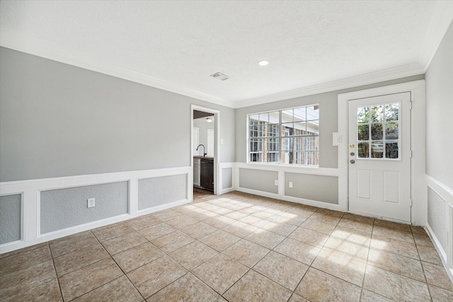 tiled spare room with a decorative wall, a wainscoted wall, recessed lighting, visible vents, and ornamental molding